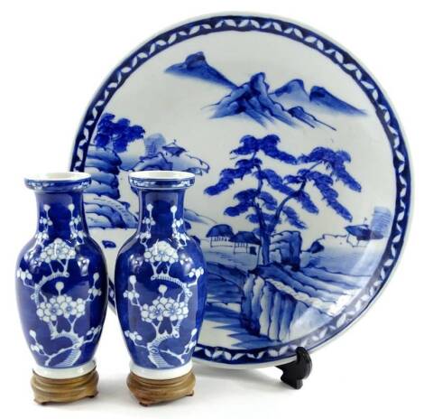 A pair of Chinese porcelain blue prunus pattern vases, 17cm H, and an oriental blue and white plate, 32cm dia.