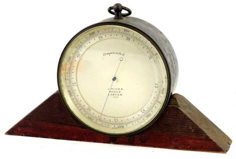 A 19thC barometer by J Hicks of London, numbered 5672, in a metal case with associated wooden stand, 12cm dia.