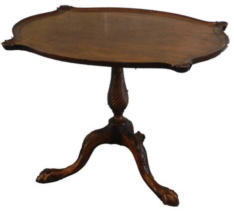 A mahogany occasional table, the rectangular top with a serpentine pie crust type border, with shell carving to each corner, on a spirally turned column and tripod base, with ball and claw feet, 70cm W.