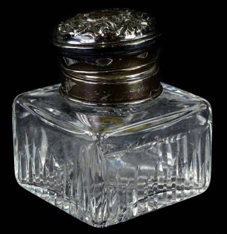 A George VI cut glass inkwell, the hinged silver lid embossed with scrolls etc., Birmingham 1943.