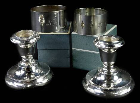 A collection of small silver, to include a pair of dwarf candlesticks (AF) and two silver napkin rings, napkin rings 1¾oz.