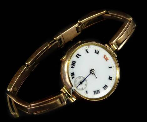 A 9ct gold wristwatch, with circular white enamel watch head, in 9ct gold casing on expanding 9ct gold bracelet, the watch head 3cm W, 22.9g all in.