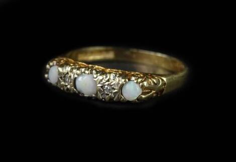 A 9ct gold gypsy ring, set with imitation opal and tiny white stones, in scroll design ring head, ring size O, 2g all in.