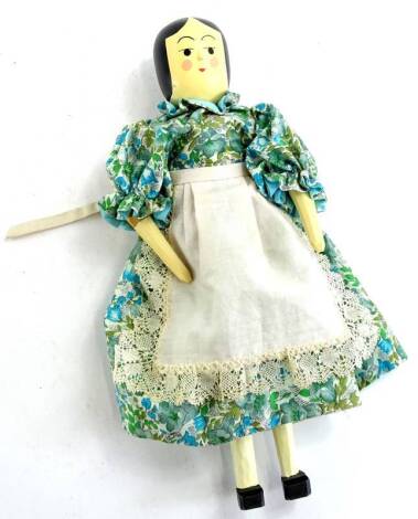 An articulated wooden peg doll, with painted face etc., possibly by Eric Horne of Topsham Devon, with clothes by his wife Christine, 30cm L.