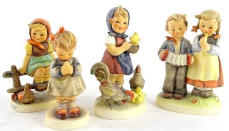 Four Goebel Hummel figures of children, to include a musician group and a chicken group, the largest 12cm H.