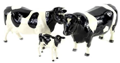 A Beswick Fresian bull, a cow and a calf (3).