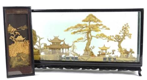 An oriental cork picture, modelled in the form of trees, storks, buildings etc., in ebonised glazed case, 60cm W and another cork picture. (2)