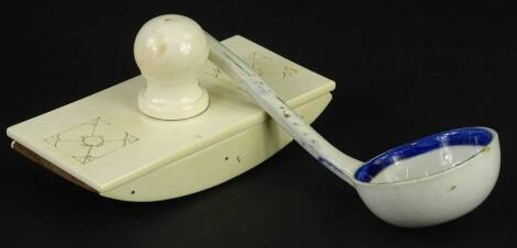 A late 19thC carved ivory desk blotter, and a pottery ladle.