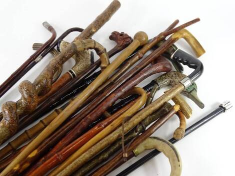 A large quantity of walking sticks, one with a carved oriental dragon handle, two duck handled examples etc.