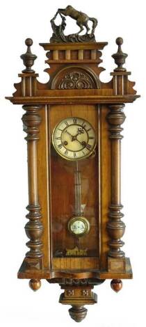 A Vienna wall clock, in a walnut case, the paper dial with Roman numerals flanked by turned pilasters, (AF), 104cm H.