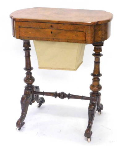 A Victorian walnut and marquetry work table, the hinged lid enclosing a writing surface, with divisions for pens etc., above a wool bag, on turned supports with stretcher and carved cabriole legs and ceramic castors, 63cm W.