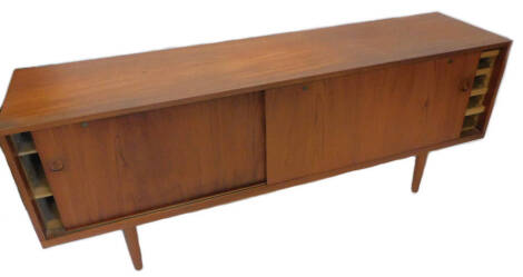 A Danish retro teak sideboard, with sliding doors, on tapering legs, 200cm W.