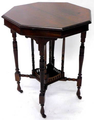 An Edwardian walnut window type table, the octagonal top on turned reeded legs with galleried under tier and ceramic castors, 59cm W.