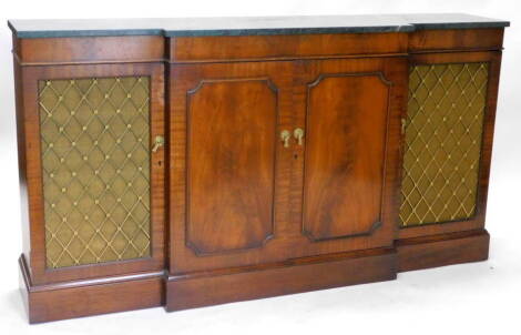 A mahogany breakfront sideboard, in regency style, with a green marble top above two panelled doors, flanked by two doors with brass grills on a plinth base, 90cm H, 35cm D, 166cm W.