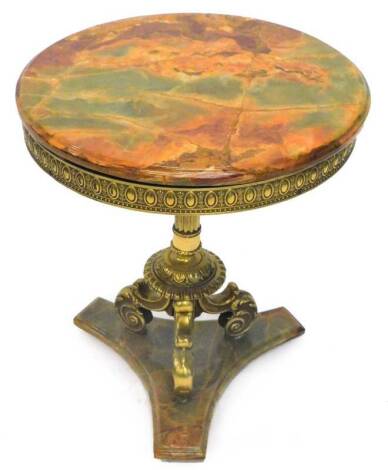 A gilt metal and onyx occasional table, the circular top with a moulded edge above a decorative frieze, on turned column tri-pod base and concave triform plinth, (AF), 50cm dia.