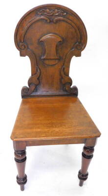 A Victorian oak hall chair, with shield shaped back and a solid seat on turned tapering legs.