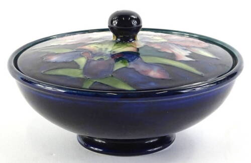 A Moorcroft iris pattern powder bowl and cover, with tube decoration to the lid, impressed marks to lid and to base, 16cm dia.