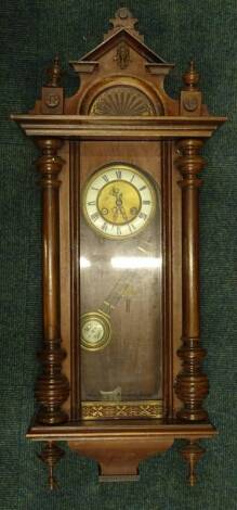 A late 19th/early 20thC walnut Vienna type wall clock, with shaped pediment, the enamel type dial with Roman numerals, above a glazed panel, flanked by turned pilasters, 71cm H. Provenance: This timepiece formed part of Luke Jerram's installation Harrison