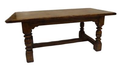 An oak refectory table, with overhang top, 4.5cm thick, channelled frieze, turned legs and H frame stretcher, 76cm H, 93cm W, 185cm L.