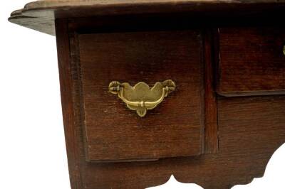 An early 18thC oak lowboy, with a moulded and shaped rectangular top having re-entrant corners, over three frieze drawers with brass engraved back plate loop handles, fret carved apron, on cabriole legs, 70cm H, 72cm W, 54cm D. - 5