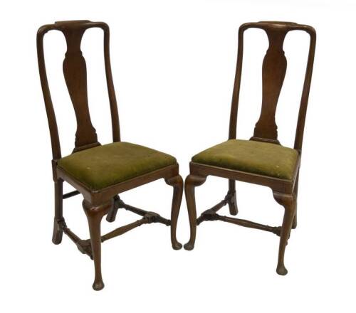 A pair of George II mahogany dining chairs, with solid splat back with raked uprights, drop in seat with rounded frame and cabriole legs joined by a H stretcher, 53cm W.