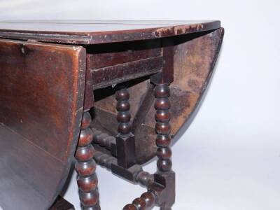 A 17thC oak gate leg table, with oval folding top, ball turned supports and square framing, 76cm H, 187cm when open. - 2