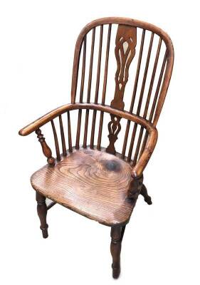 An early 19thC yew wood highback Windsor chair, with pierced splat, turned legs and crinoline stretcher.
