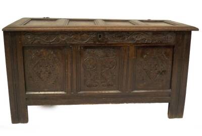 A 18thC oak coffer, with four panel moulded top, the frieze carved with roundels and trailing foliage over three panels with floral lozenges, roundels and thistles, channelled muntins and raised on stiles, 63cm H, 120cm W, 55cm D.