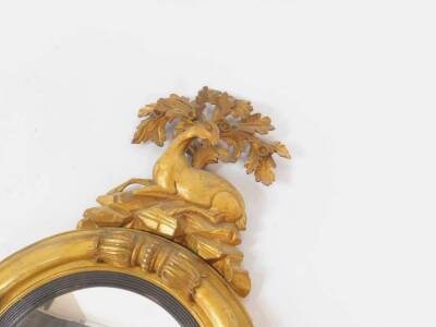 A Regency circular convex girandole wall mirror, with stag and oak leaf surmount to the gilt gesso cushioned ring frame with bead and leaf moulded collars, with black reeded slip frame and foliate scroll ornamentation below, 127cm H, 67cm Dia. - 3