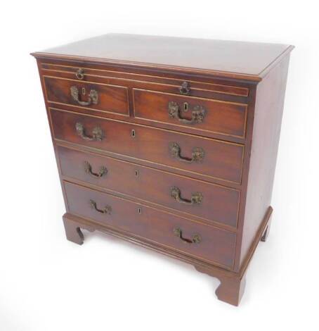 A George III mahogany bachelor's chest, of two short and three long drawers and a brushing slide, with cock beading and cast brass scroll handles, on shaped bracket feet, 90cm H, 85cm W, 50cm D.