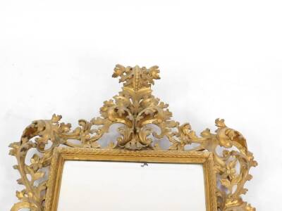 A large 19thC Florentine giltwood mirror, with a cascading foliate scroll crest and set with a bevelled rectangular plate within a scale pattern inner frame and further foliate scrolls and flower heads, 124cm H. - 2