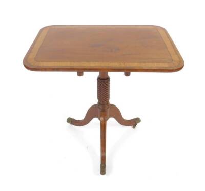 A Regency figured mahogany tilt top tripod table, probably Scottish, the rectangular top with rounded corners and figured palm wood veneered banded border within ebony stringing, on a turned and whorl fluted slender column and haunched reeded tapered legs