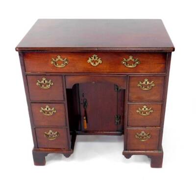 A George II mahogany kneehole desk or dressing table, with moulded and rounded rectangular top, oak lined frieze drawer over an apron drawer and cupboard beneath, flanked by three drawers each side on bracket feet, 75cm H, 77cm W, 48cm D. - 4