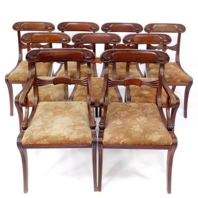 An exceptional set of nine Regency mahogany dining chairs, including two carvers, having fluted scroll cresting rails, pollard oak veneered panels to the bar backs, the carver arms scrolling and terminating in lion paws, drop in seats on reeded sabre legs