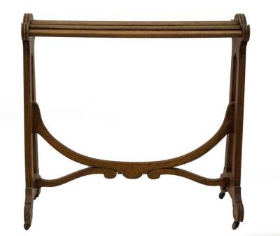 A Victorian walnut saddle stand, with slatted rail top, open slab sides, with reeded detail and scroll feet, on brass castors, and supported by a loop and scroll fluted stretcher, 90cm H, 92cm W, 47cm D.