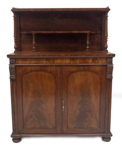 A William IV flame mahogany chiffonier in the manner of Gillows of Lancaster, with double shelved back, on baluster turned supports with tray top, the base having two arch panel doors, revealing shelves enclosed by reeded columns with acanthus scroll and