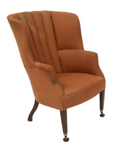 A 19thC wingback barrell armchair, with pink upholstery and square taper legs with brass cup castors, 107cm H, 75cm W.