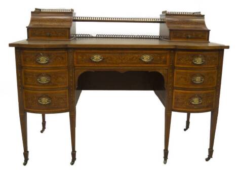 A late Victorian marquetry writing desk by Maple & Co, having brass gallery top with cavetto lift flaps and fitted drawers, in the Carlton House style with marquetry panels of baskets and scrolling foliage, part leather inset top with satinwood crossbandi