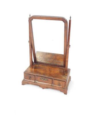 A George III walnut dressing table mirror, with adjustable shaped rectangular mirror with replacement plate, but sold with original plate, on slender taper supports, the base fitted with three drawers and raised on ogee bracket feet, 56cm H.