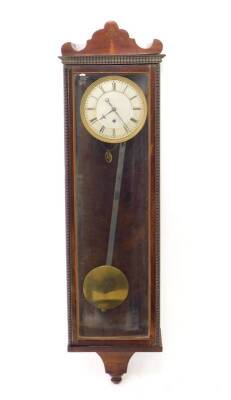 A small Biedermeier style Vienna wall clock, with silvered circular dial having Roman numerals and blued steel hands, dead-beat escapement, the slender glazed mahogany case of plain design with arched scrolling pediment and beaded moulded borders, 60cm H.