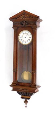 A late 19thC Vienna regulator wall clock, with white enamelled dial and eight day movement, in an architectural figured walnut case with arched pediment and flat reeded pillasters to the single glazed door, 131cm H.