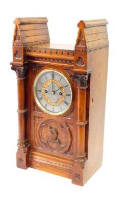 A Victorian gothic oak cased mantel clock, by John Carter, 61 Cornhill, London, silvered circular dial bearing Roman numerals around a red and gilt painted band of clover, eight day twin barrel movement with hour strike, the case of double roofed tower fo