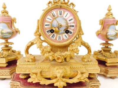 A 19thC gilt metal clock garniture comprising mantel clock of 9cm Dia. enamelled Roman numeric dial centre surmounted by an urn in a classical case set with garlands, masks and flower heads, revealing an eight day movement and flanked by two urn garniture - 2