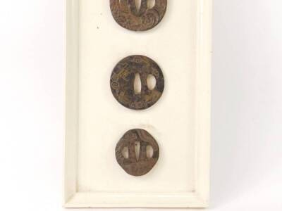 A small collection of 18thC and 19thC Japanese iron Tsuba, some with inlaid brass and copper decoration, (6), mounted on a painted and framed board. - 4