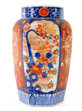 An early 20thC Imari vase, of tapered hexagonal form decorated with panels of flowering branch decoration and decorative shields on a red ground, 24.5cm H.