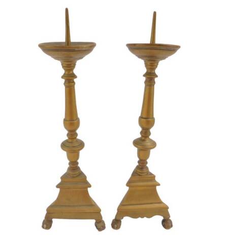 A pair of 17thC brass pricket candlesticks, with baluster turned columns, raised on a triform bases and ball and claw feet, 40cm H.