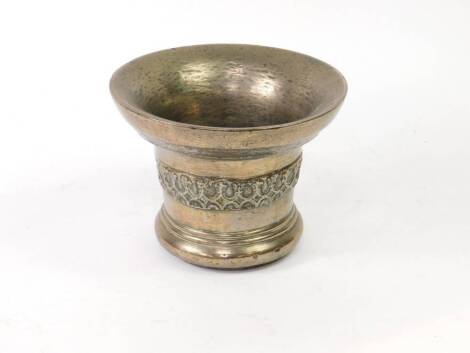 An 18thC Eastern mortar of bell shaped form with a raised central banding, 18cm high.