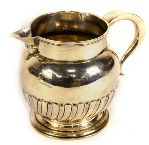 A Victorian silver ale jug, of bellied semi whorl fluted design, with a tapered double scroll handle having heart shaped terminal and raised on a stepped circular foot, London 1889, makers Walter & John Barnard, 16oz, 14.5cm H.