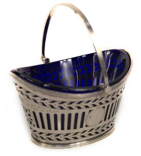 A late Victorian silver sugar basket, with bands of pierced decoration and scroll engraving, having a blue glass liner and reeded swing handle, Sheffield 1895, makers Fenton Bros, 3oz, 11cm L.