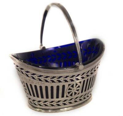 A late Victorian silver sugar basket, with bands of pierced decoration and scroll engraving, having a blue glass liner and reeded swing handle, Sheffield 1895, makers Fenton Bros, 3oz, 11cm L. - 2